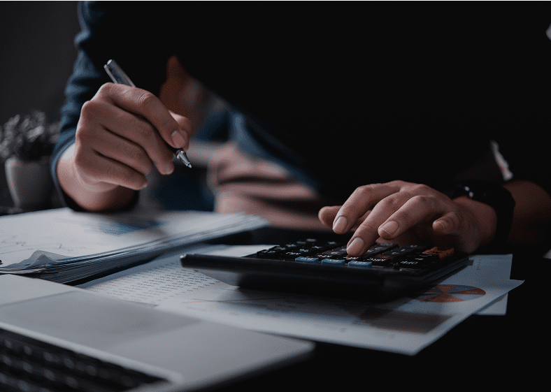 Person using calculator and writing on paper.