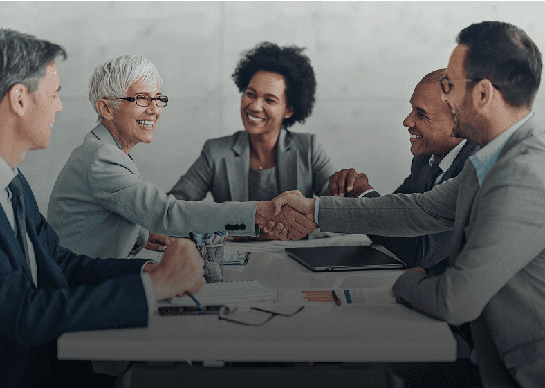 Business meeting with handshake and smiles.